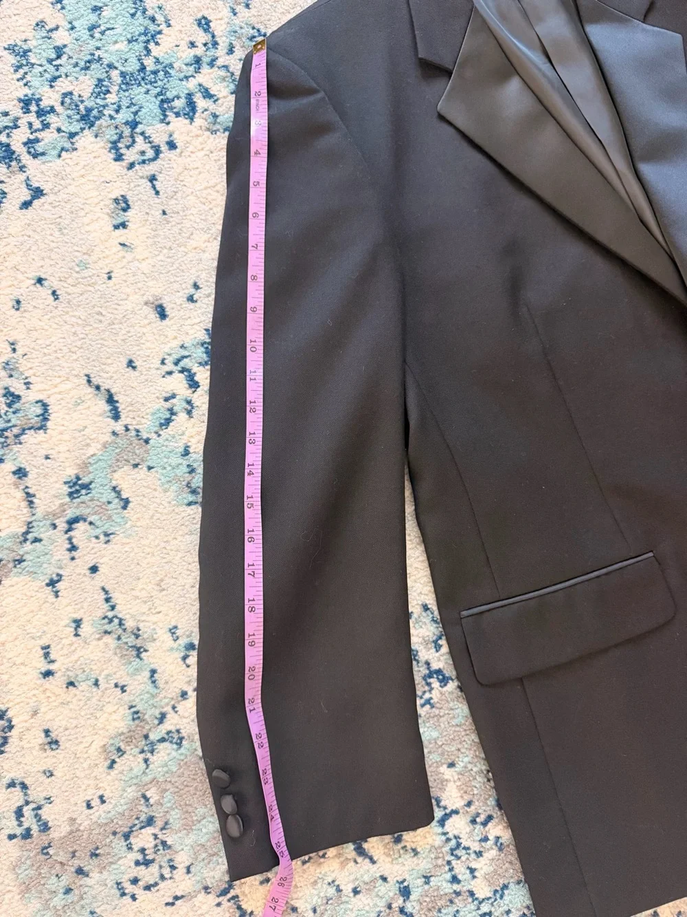 black Versini tuxedo jacket with a single-button closure and satin notch lapels.
